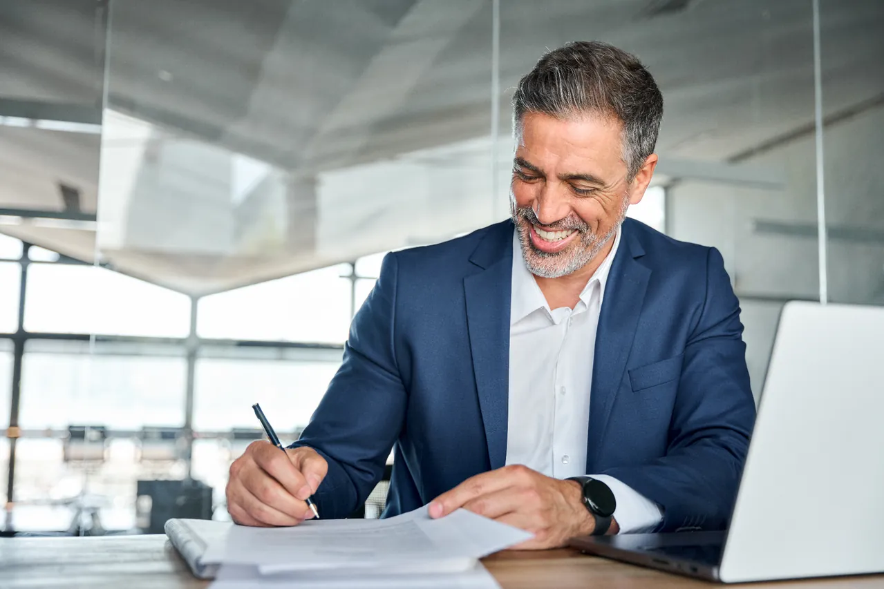 Professional client signing documents at a desk