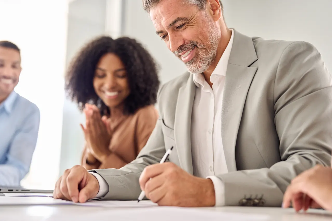 Client signing documents with family nearby